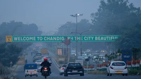 Traffic on a busy road under the ‘Welcome to Chandigarh — The City Beautiful’ signboard during an early evening haze.