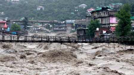 A bridge stands amid raging floodwaters in Himachal Pradesh after extreme rainfall.