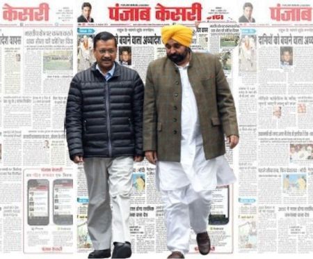 Arvind Kejriwal and Bhagwant Mann with Punjab Kesari newspaper backdrop