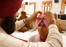 A Sikh elder tying a turban during a dastaarbandi ceremony