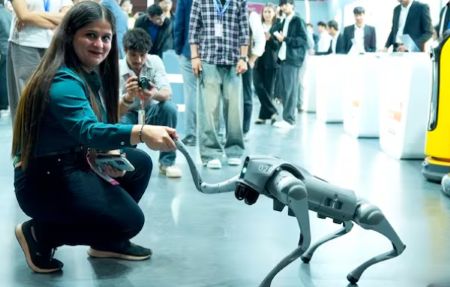 Representative from Galgotias University interacting with robotic dog at AI Summit pavilion