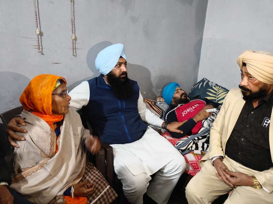 SAD youth leader consoling an injured Sikh youth at his Ludhiana residence as family members look on after alleged police brutality.