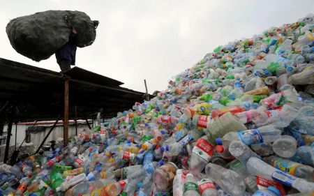 Large pile of discarded plastic bottles at a waste site